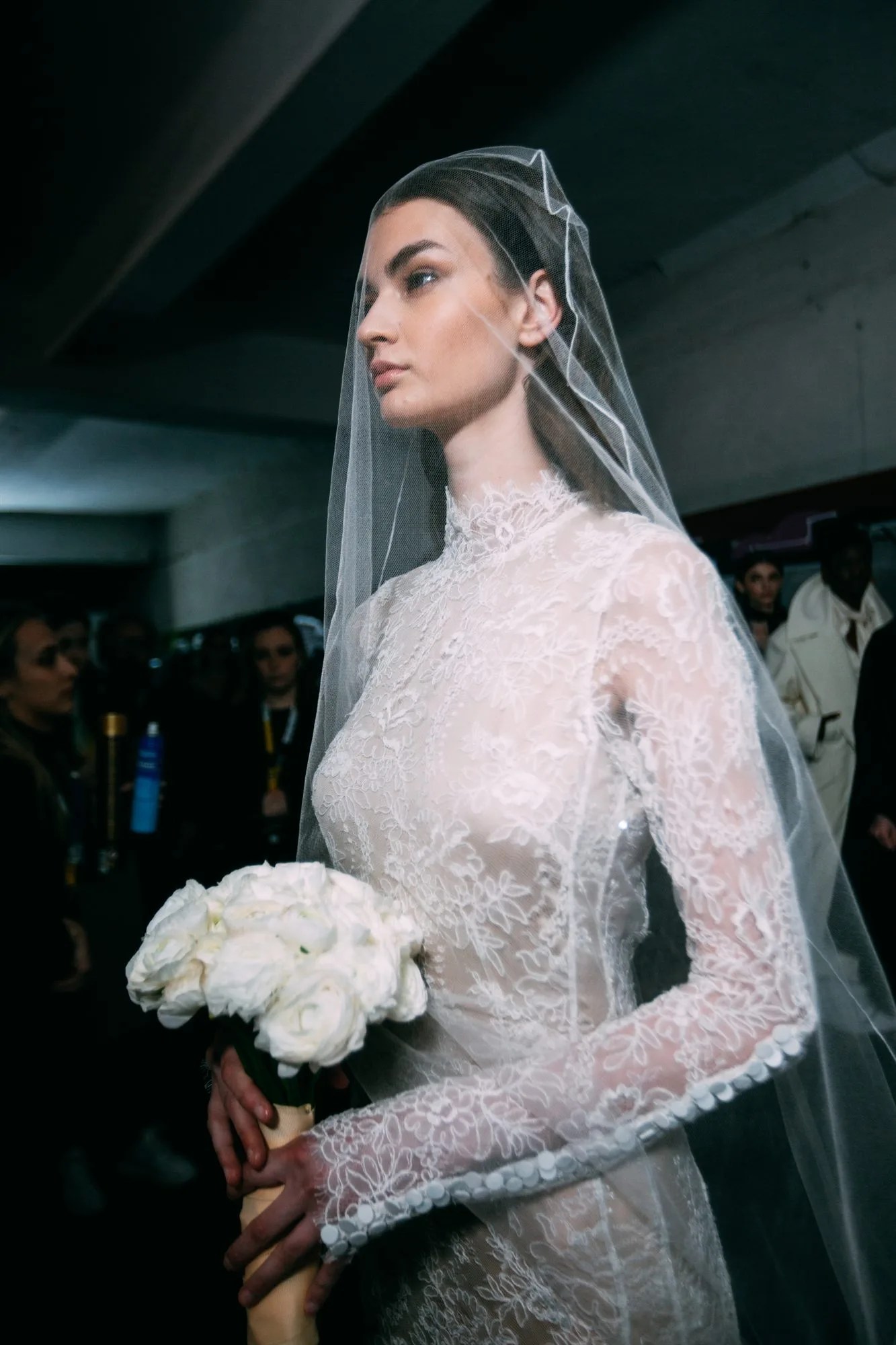 Sposa con velo e bouquet di rose bianche