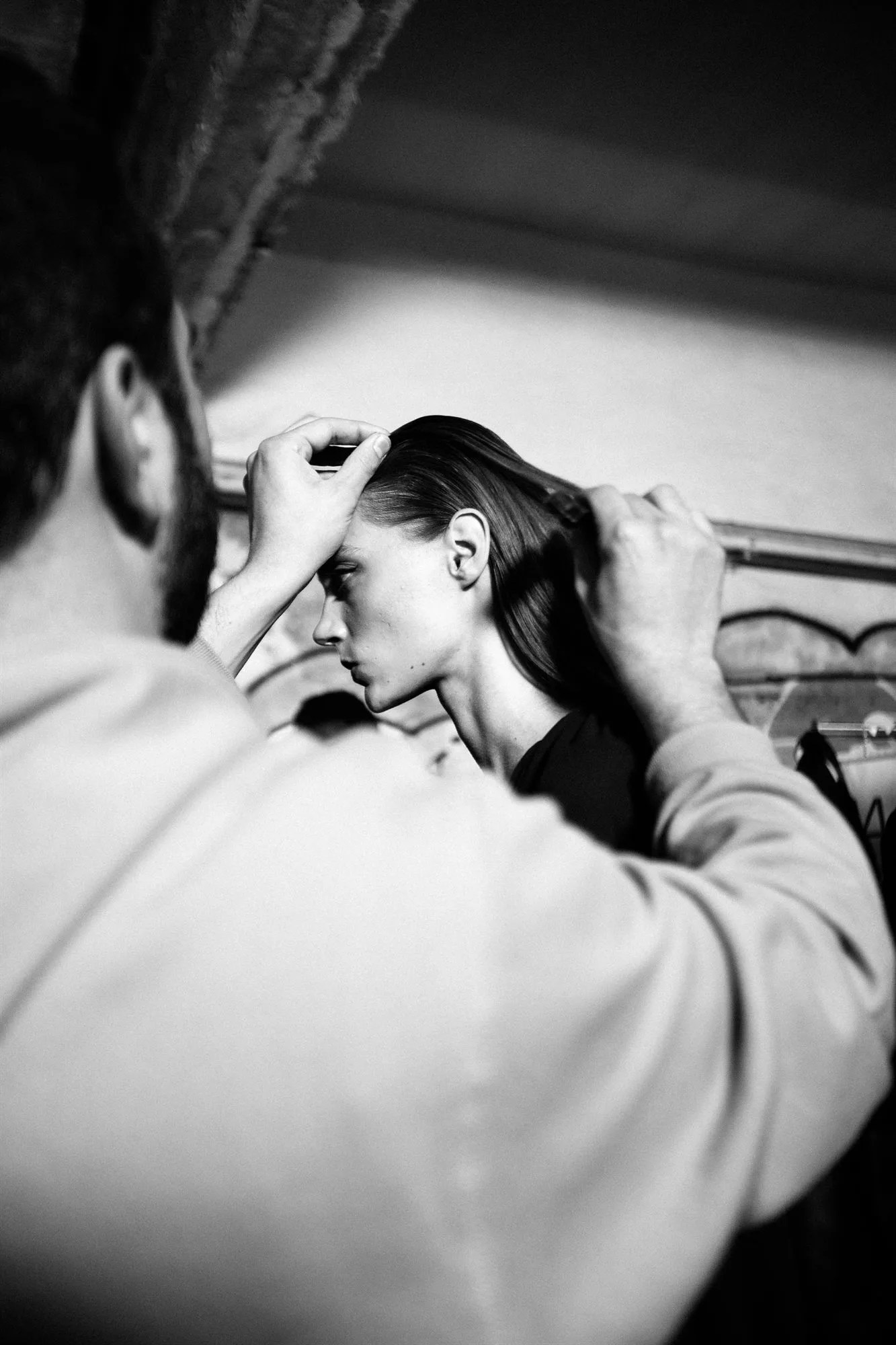 Hair stylist al lavoro su una modella, foto in bianco e nero