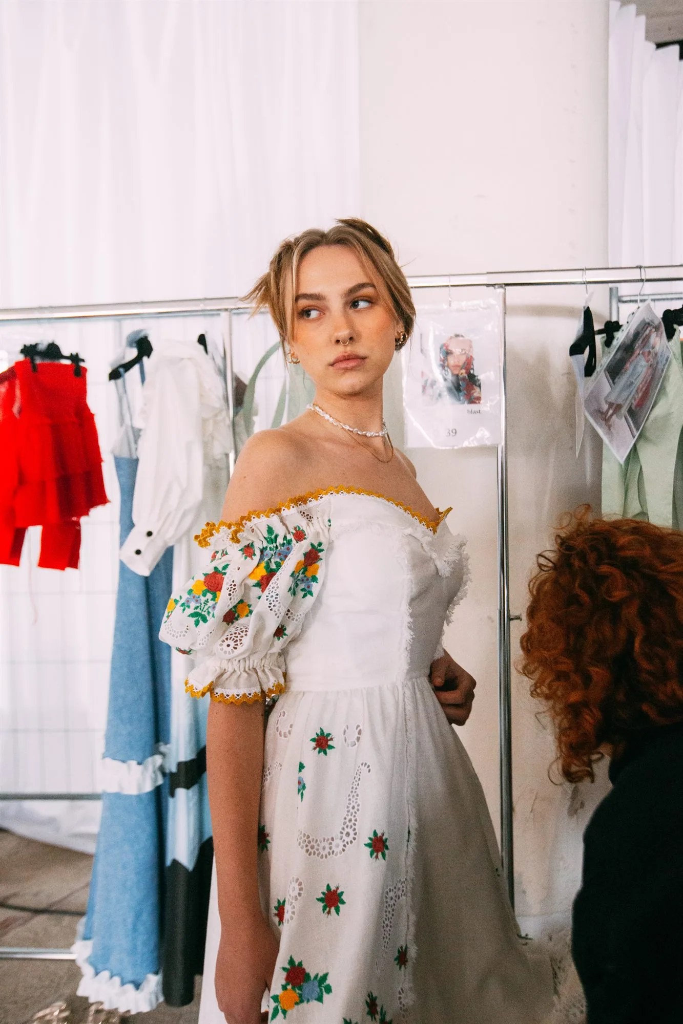 Modella con capelli biondi raccolti nel backstage di una sfilata