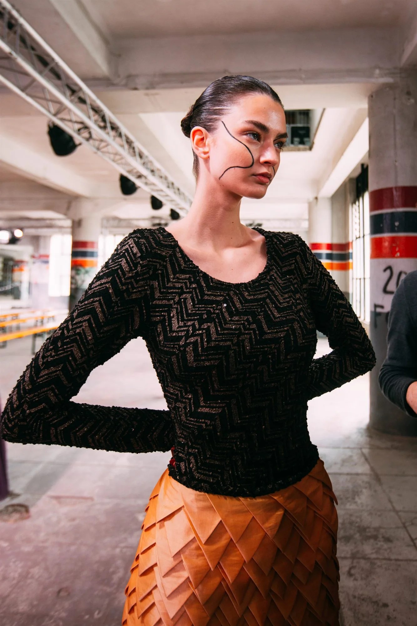 Chignon tirato e occhiali, modella nel backstage