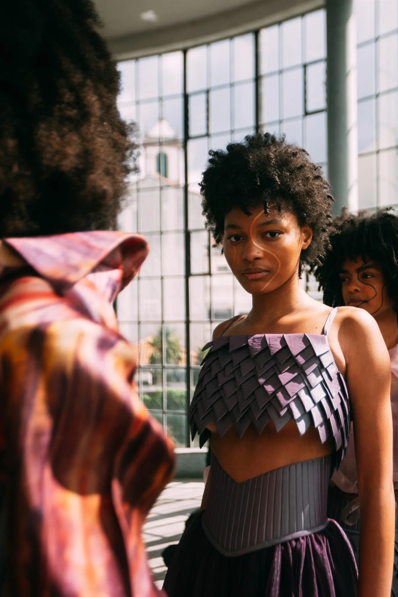 Modella con capelli ricci naturali nel backstage