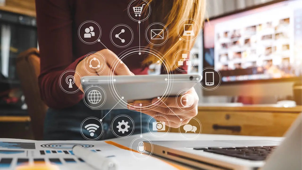 Woman managing Digital Marketing activities on tablet with connected icons