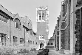 St Mary-of-Eton church (1890), London E9, bell-tower gate and courtyard flanked by church (r) and hall (l), c.1950