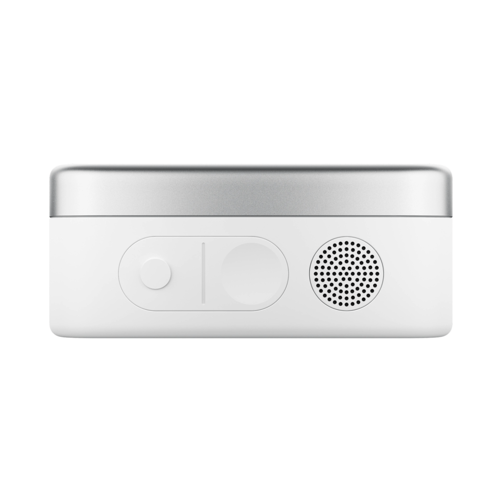 A top view of a compact white electronic device with a silver edge, featuring two buttons and a speaker grille.