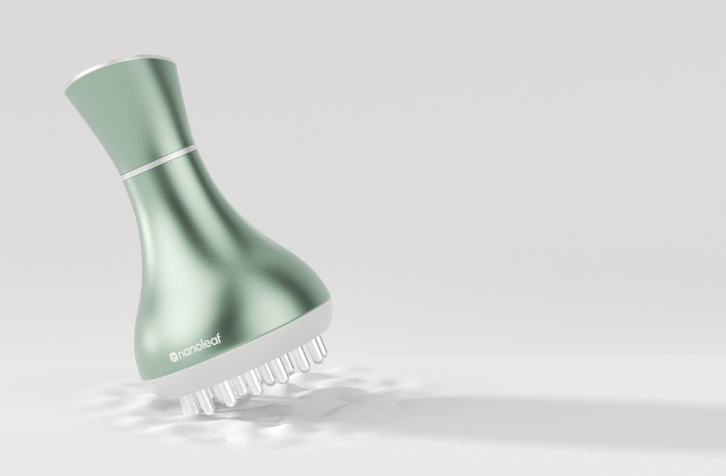 A sleek green hair care device with a tapered top and multiple rounded bristles, designed for scalp massage and stimulation.
