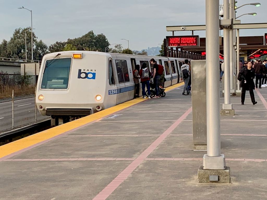 BART MacArthur Station platform with train.