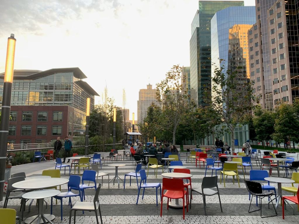 SF Transbay Terminal - Salesforce Photo of SF Salesforce Transit Center rooftop park showing cafe chairs and buildings..