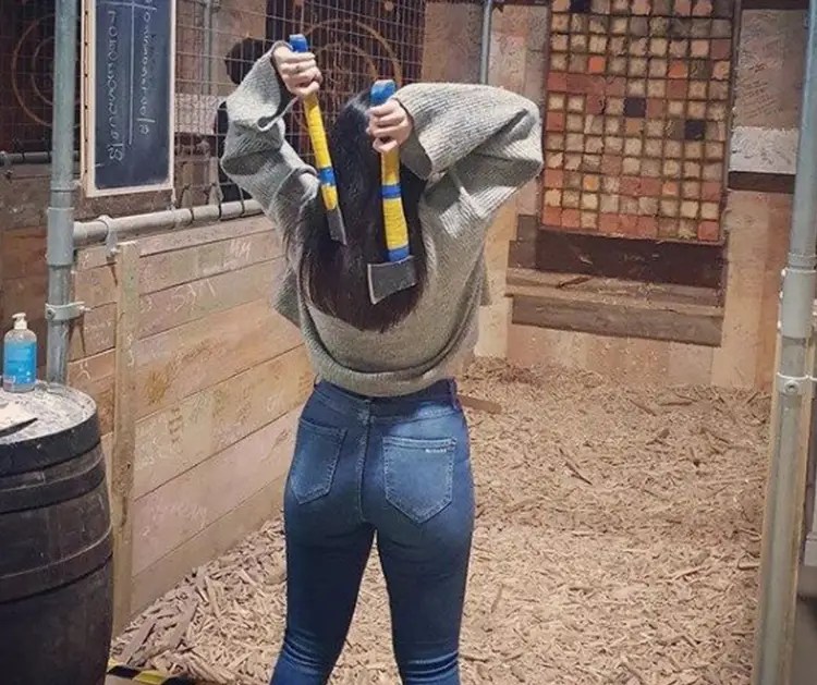 Axe throwing in Peterborough - A Woman throws two axes at tar