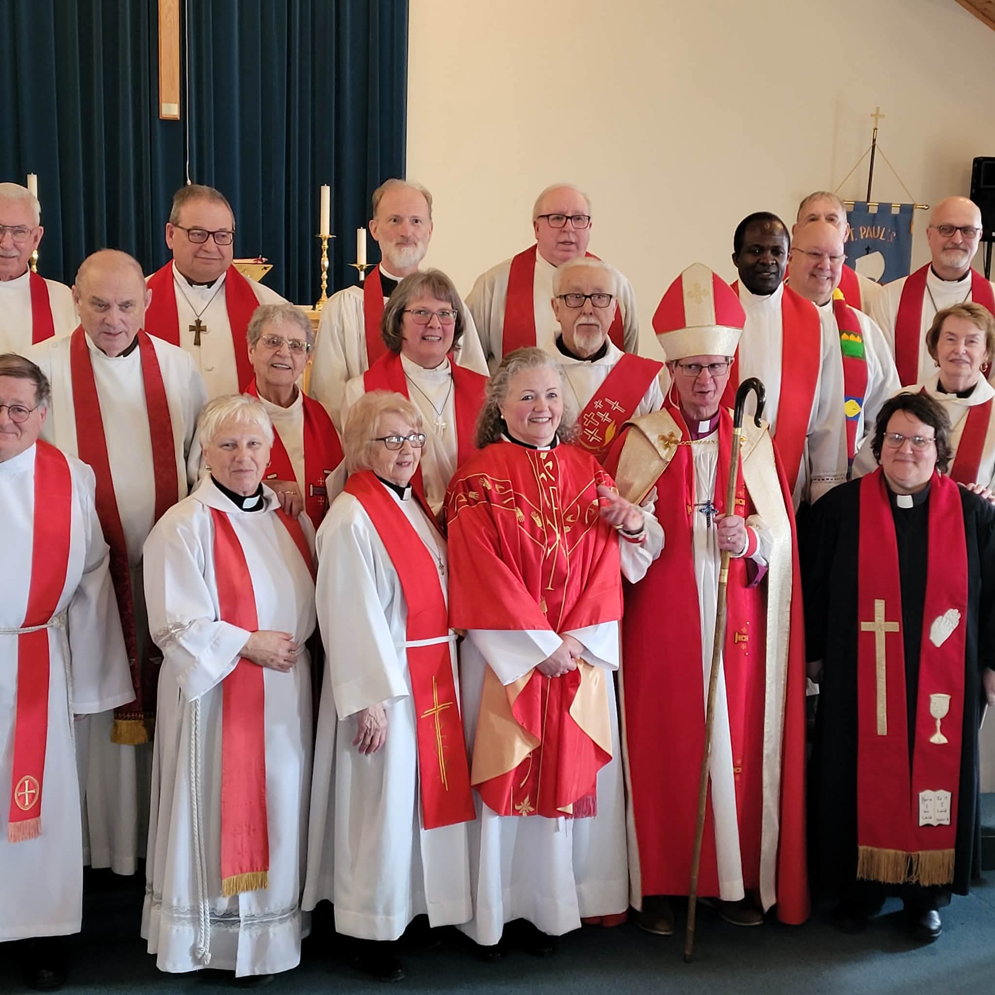 a group of clergy dressed with red stoles