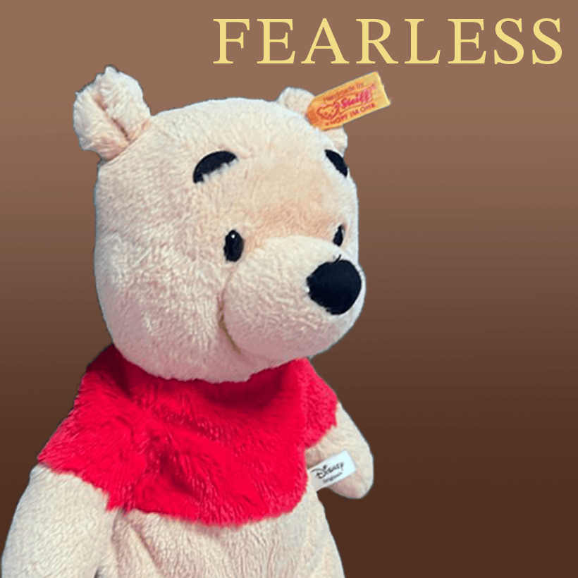 Stuffed Winnie the Pooh looking to the side with the text "Fearless" written in the top right corner