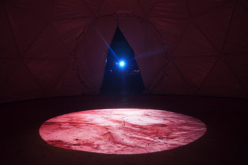 Projection of A Baker's Dozen: A Lunar Study in Variations of Size and Shape' onto the bare ground at The Earth Sanctuary, central Australia. Copyright Anna Dakin