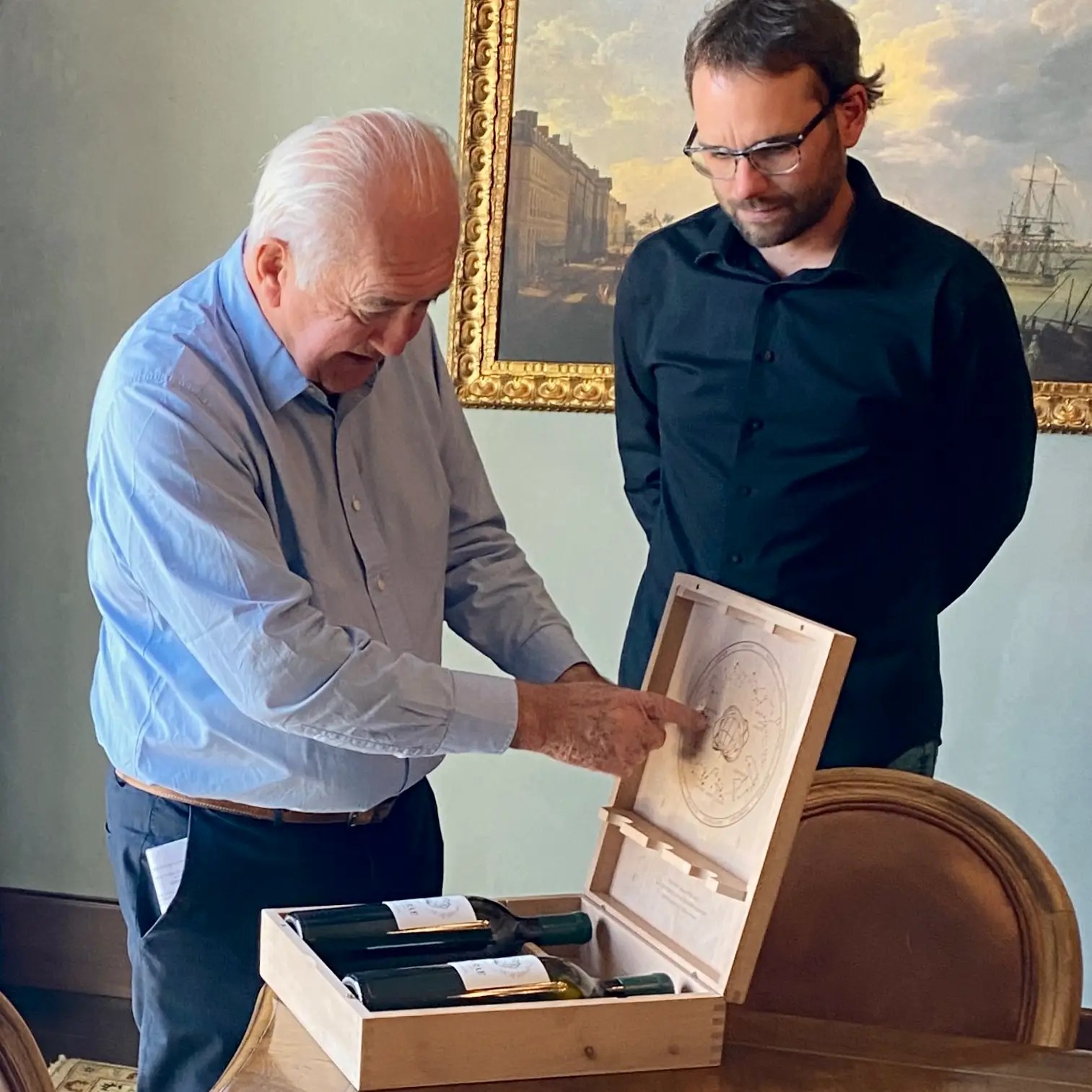 Alfred Tesseron (left) showing the zodiac symbols on the inside of the PYM-RAE's wooden case with Jérôme Ledit (Right)
