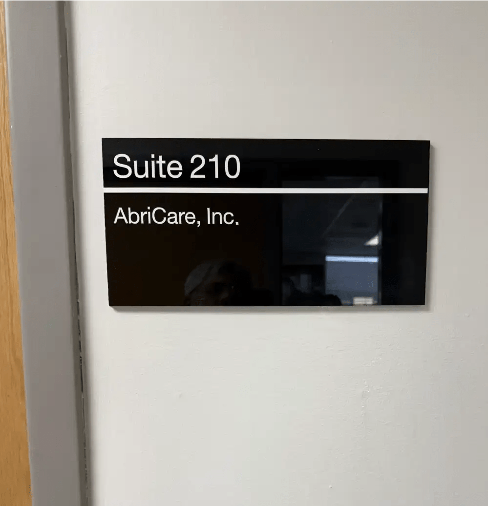 AbriCare Inc suite sign with clean lettering mounted outside office suite