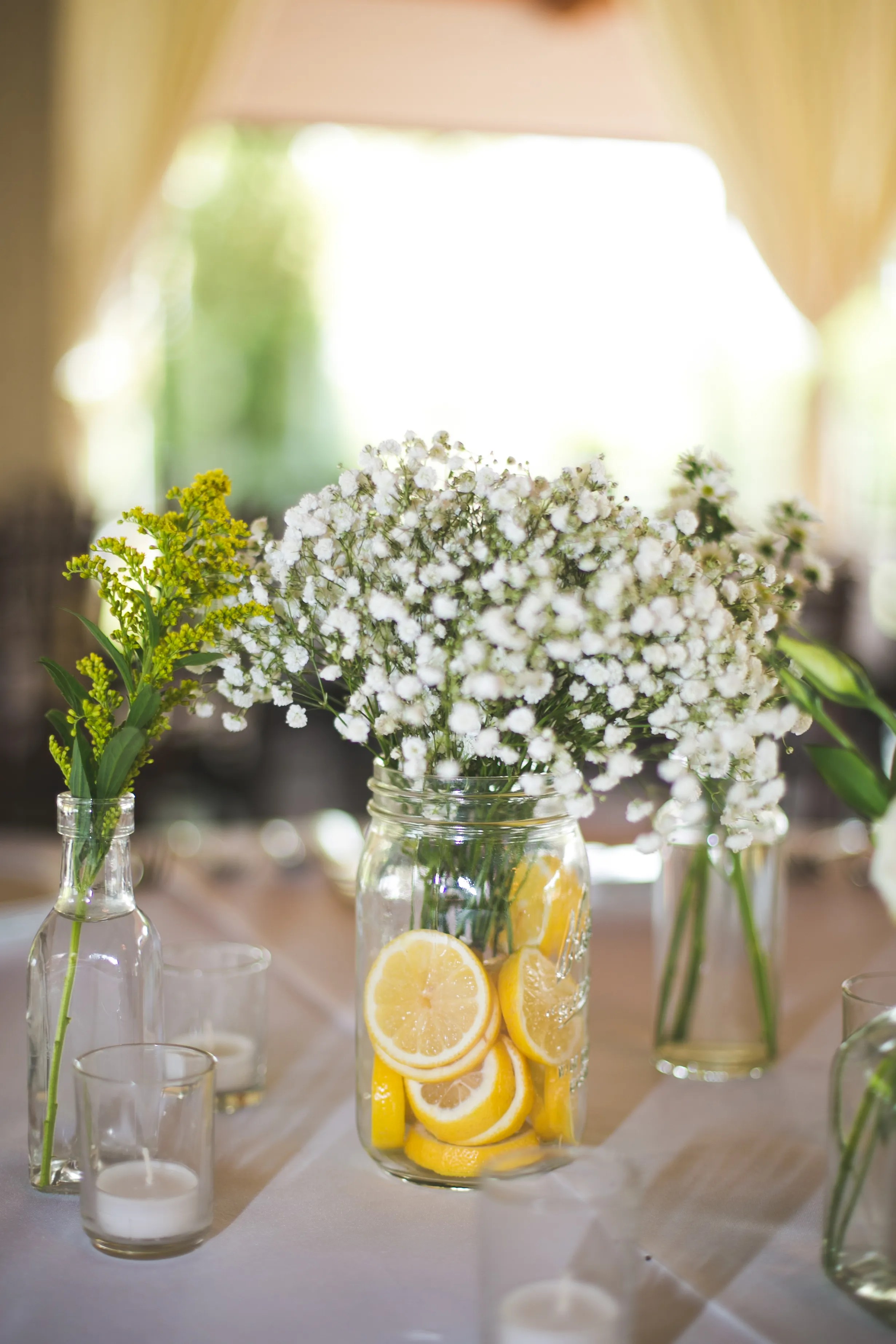 Tree stump centerpieces with mason jars. Mason Jars with Babys Breath and Lemon Table Decor