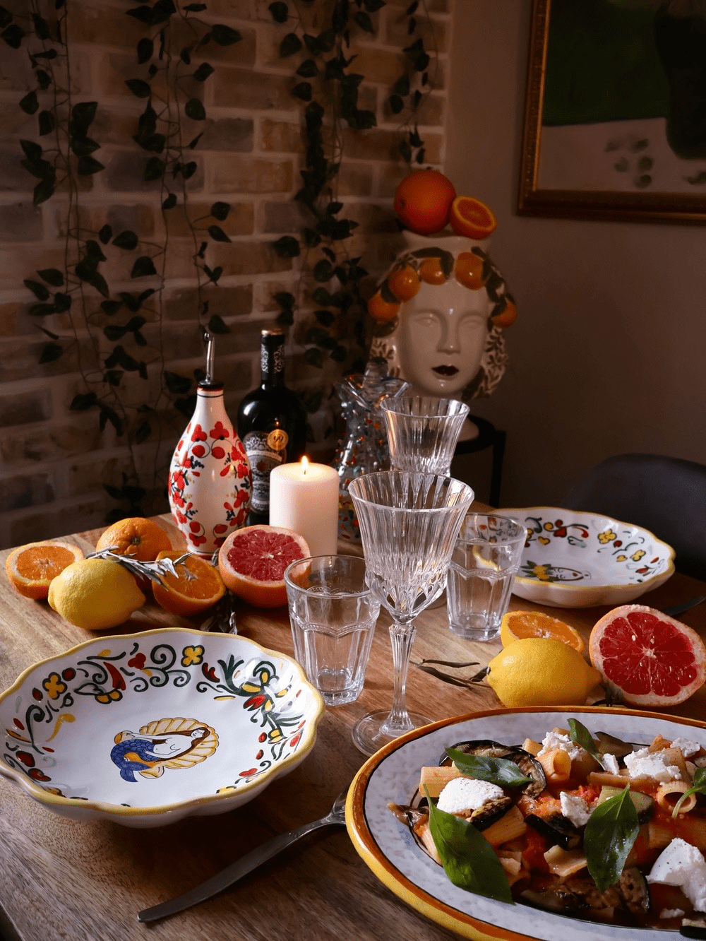 Italian table styled with colorful ceramics and fresh citrus. 