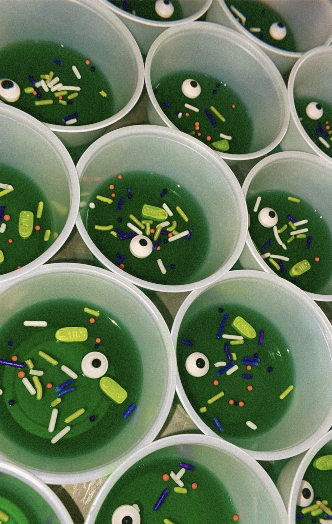 Halloween monster Jell-O shots with candy sprinkles and candy eyeballs