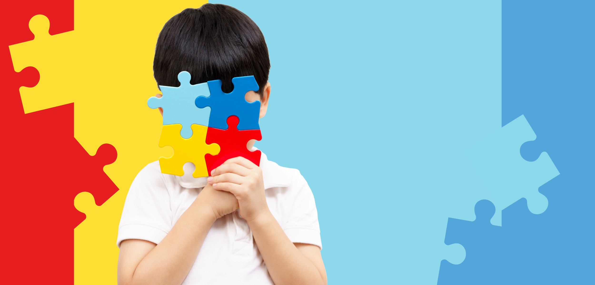 Child holding colorful autism awareness puzzle pieces