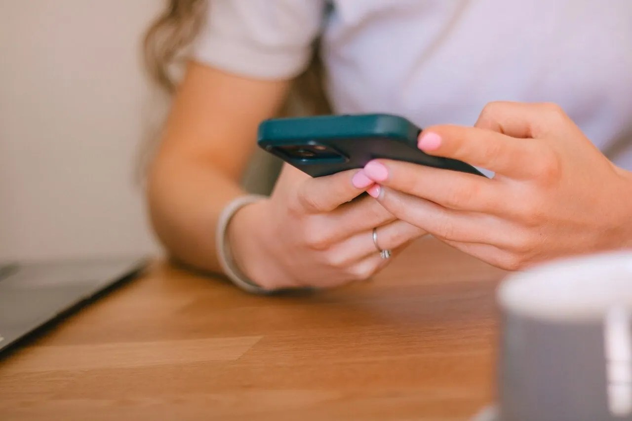 Person using a smartphone for travel eSIM connectivity and mobile data management