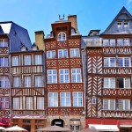 Colourful half-timbered buildings lining Place des Lices in Rennes, France.