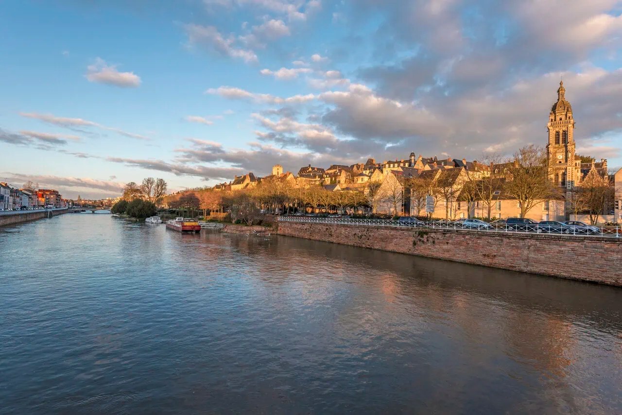 The Sarthe River and historic skyline of Le Mans at sunset, France.