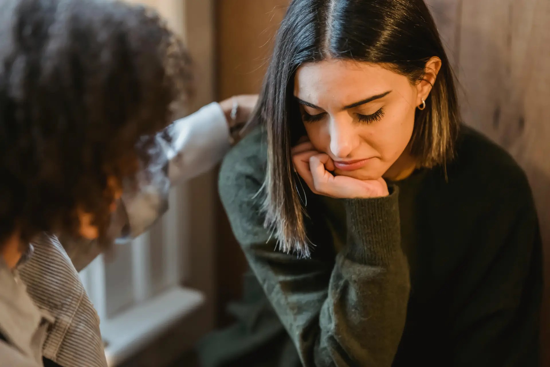 Person offering comfort to a friend who appears sad, symbolizing support for someone with depression