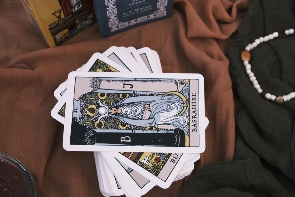 Carte tarocchi sparse su tessuto con perle per letture di amore