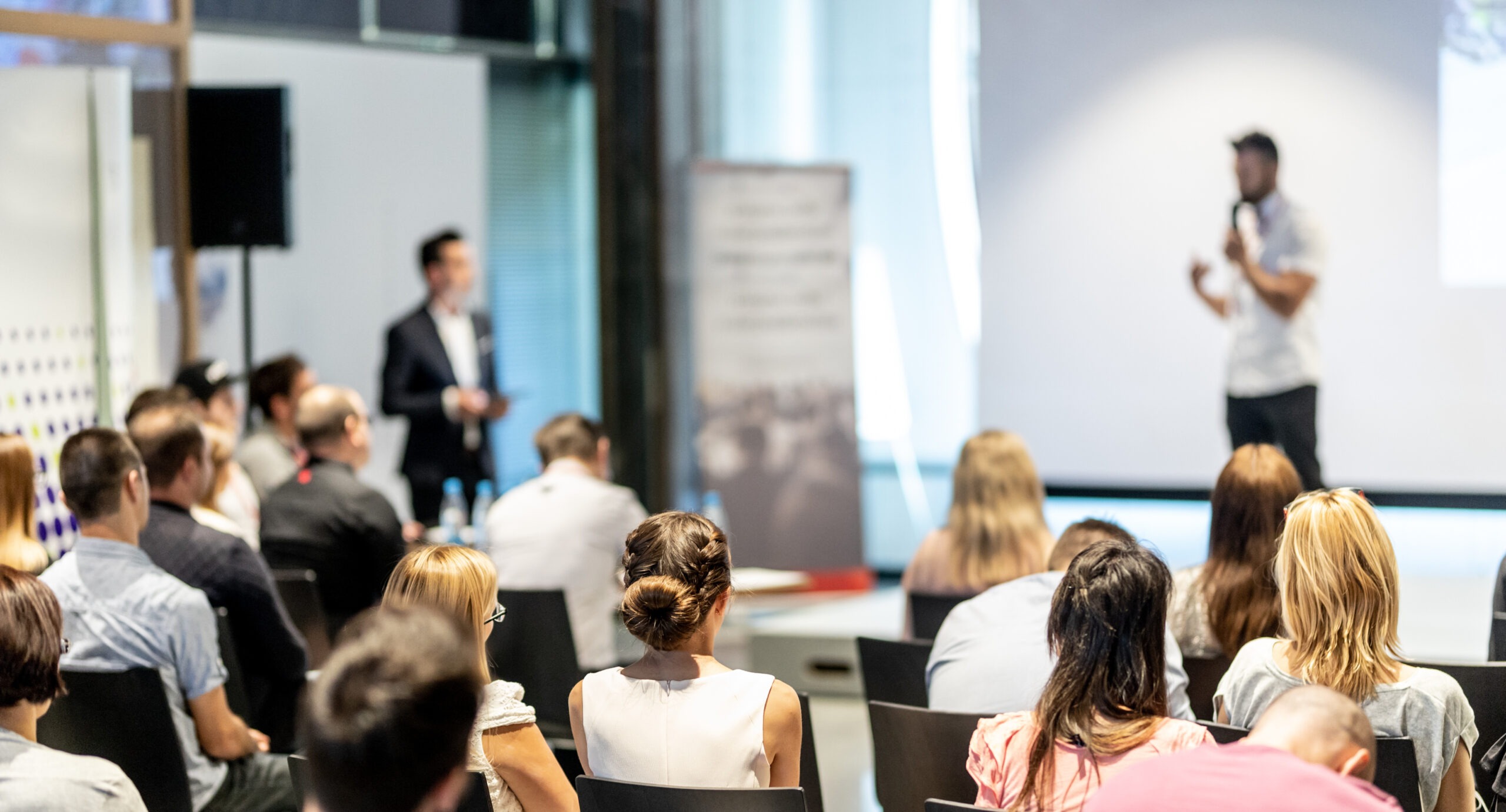 Male business speaker giving a talk at business conference event.