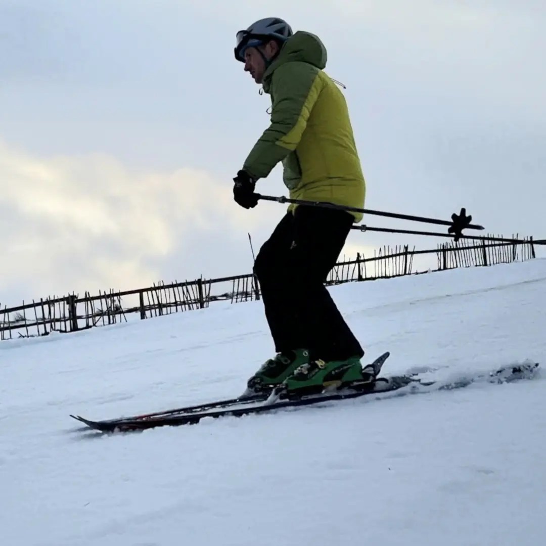 skier on piste with snowfence
