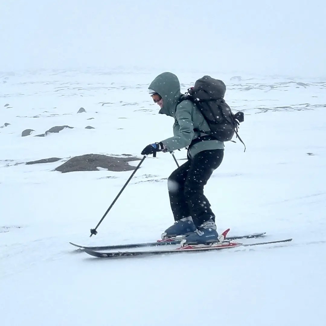 woman skiing in mist between rocks off piste