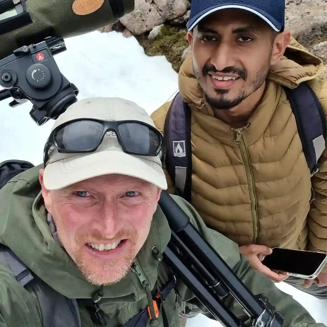 two men looking for wildlife in the rocky and snowy cairngorms mountains