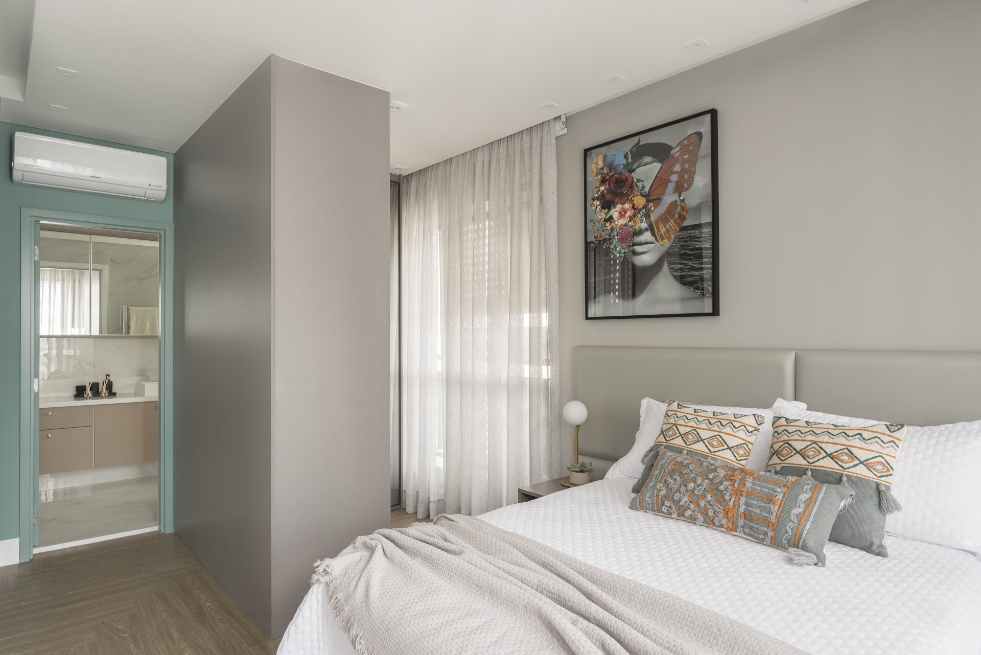 No quarto, a cabeceira desenhada em retângulos foi estofada em facto e é acompanhada por um móvel lateral.