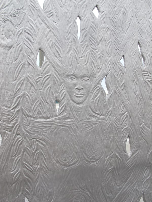 Detail of Paraje. The sculpture’s west face depicts a willow tree, while on the east face a willow spirit, shown here, emerges mysteriously from the tree. The folds of the willow spirit’s dress become the roots of the tree and the spirit’s upheld arms become branches.