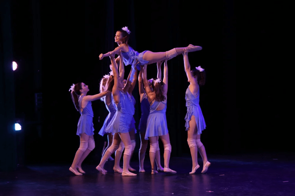 Group of dancers lifting a performer in a joyful dance performance