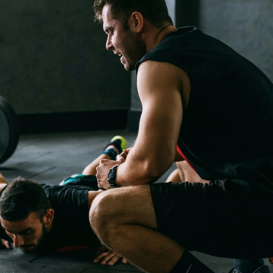 Two athletes exercising on a gym floor