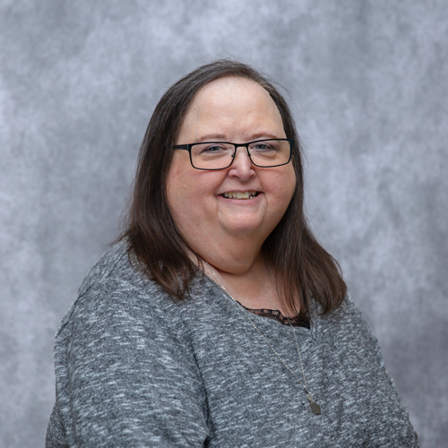 Portrait of Christia Williams in front of grey backdrop