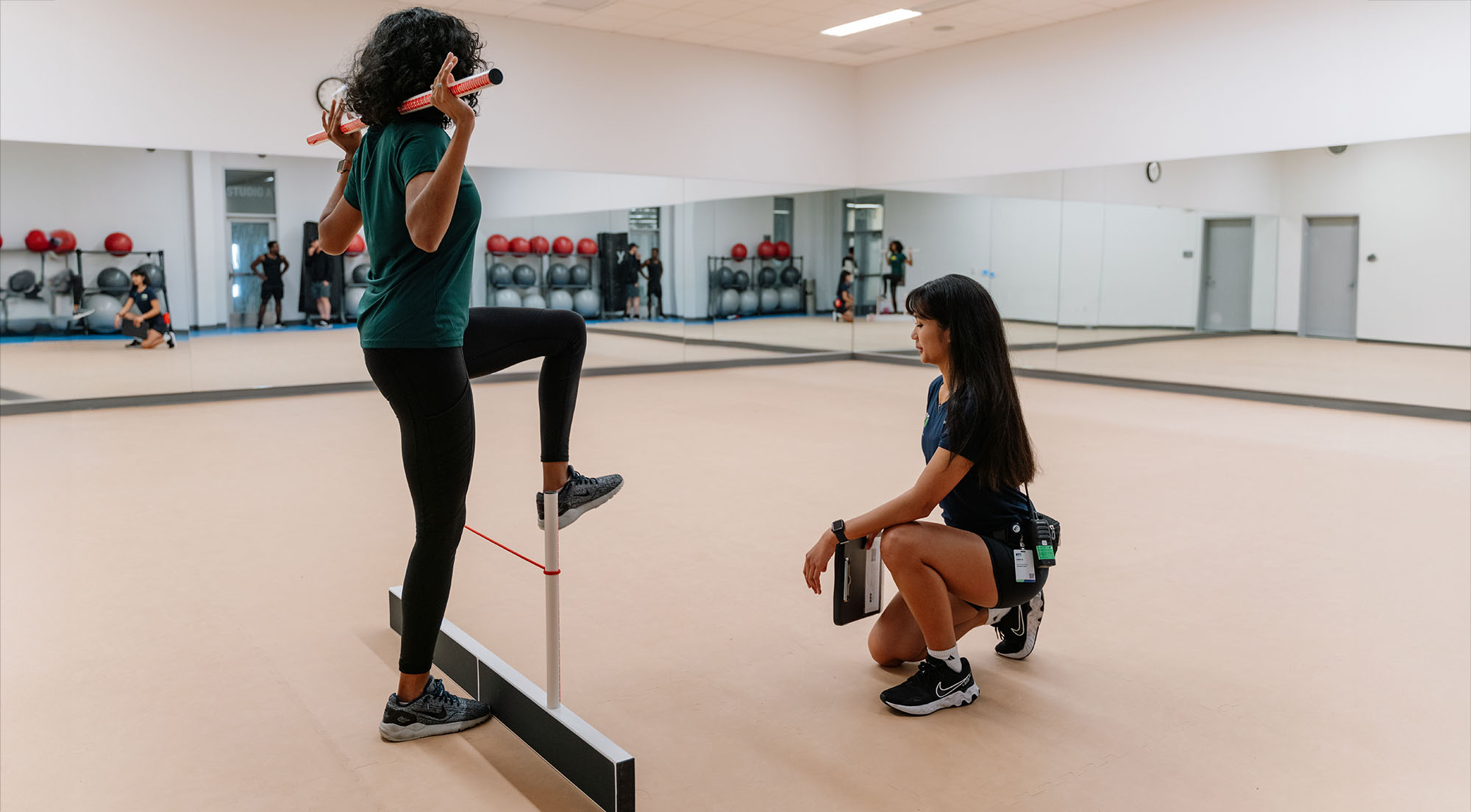 Personal trainer assisting a client with a workout