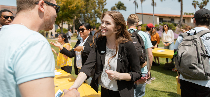 Student Government leader shaking hands with another student