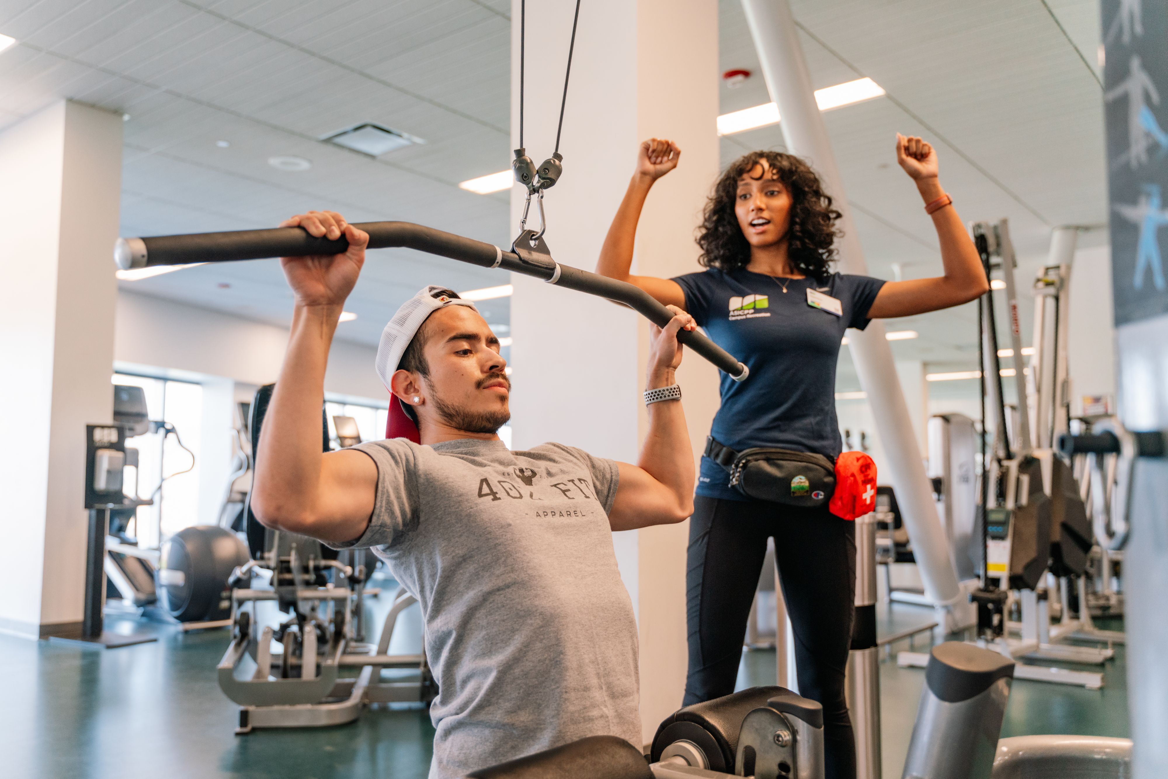 a trainer showing someone how to do a pull down