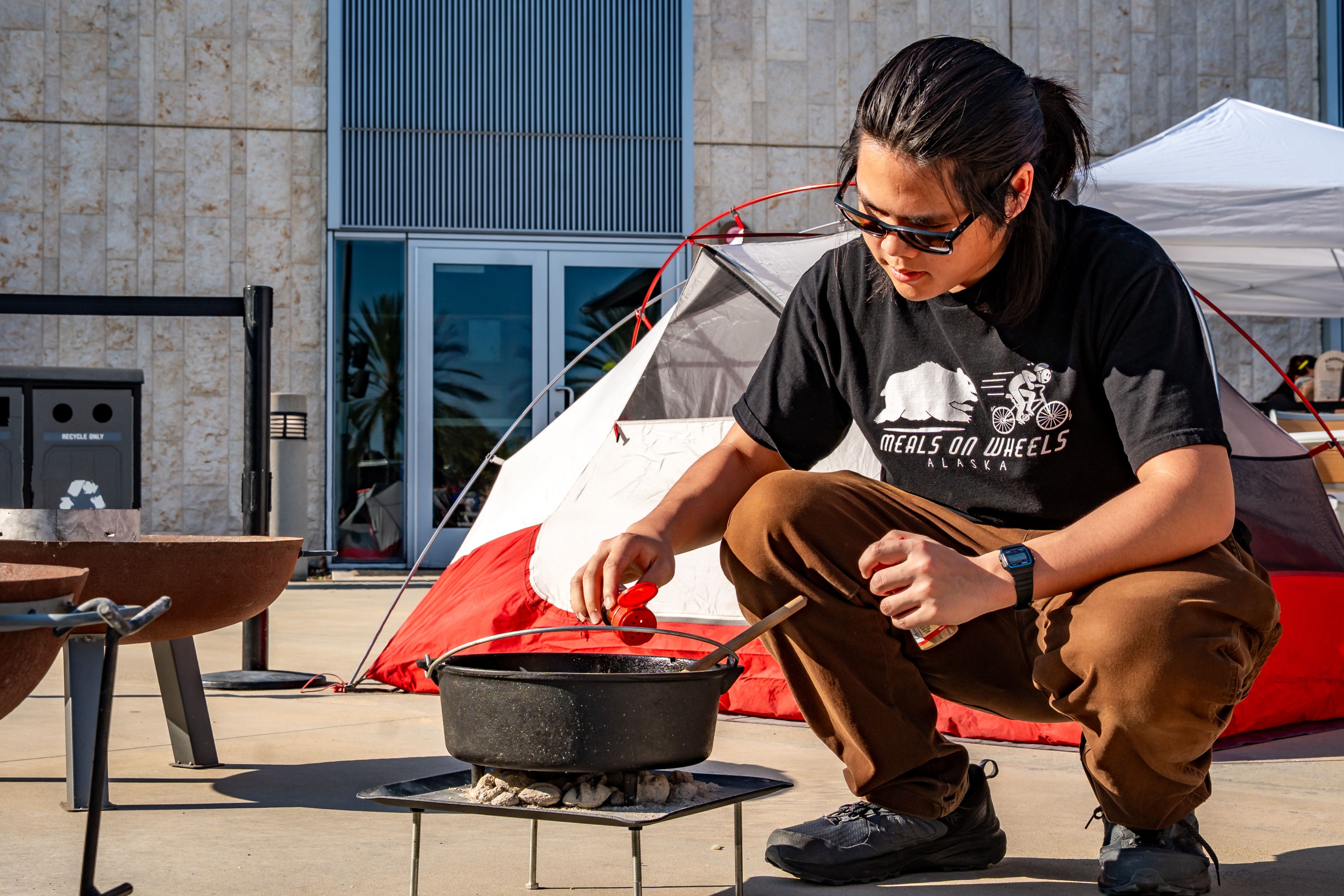 a person seasoning a pot of food