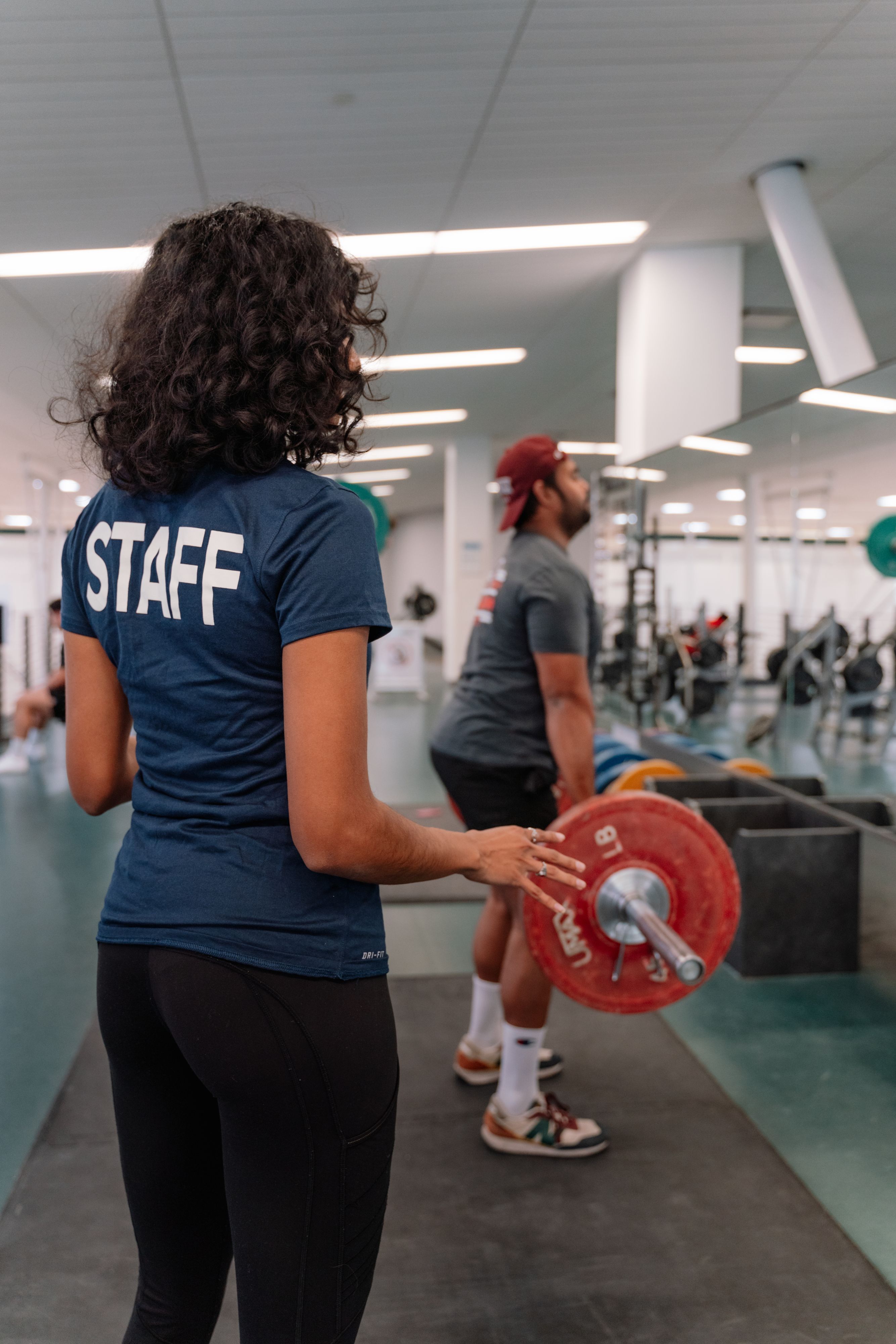 Staff training a student in power lifting