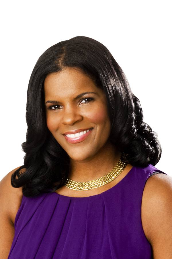 A woman with dark hair and a purple top smiles at the camera. She is wearing a gold necklace, her serene expression reflecting the relief of securing child support for her family.