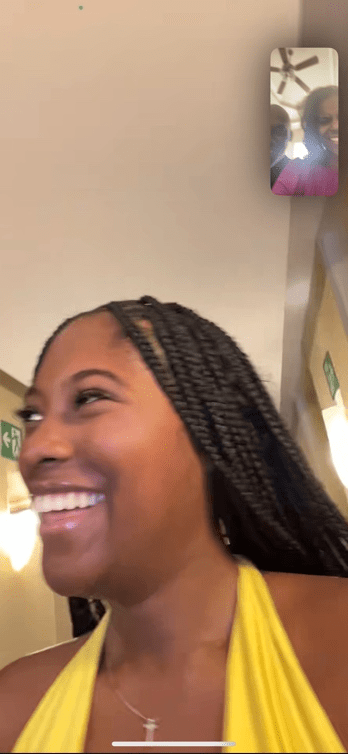 A person smiling with braidsDescription automatically generated
