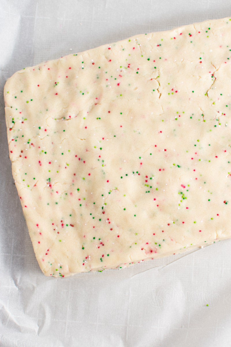 Closeup of shortbread dough pressed into a rectangle on parchment paper