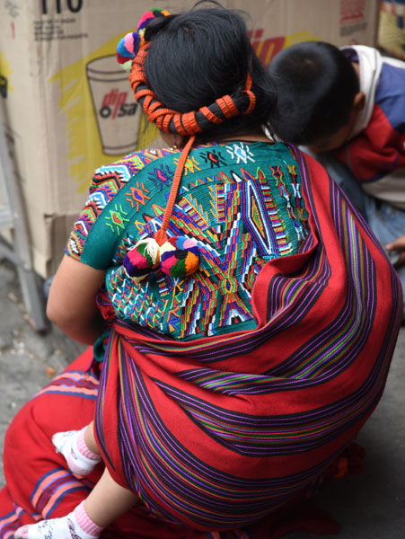 A weaver from Nebaj carries her baby the traditional way.
