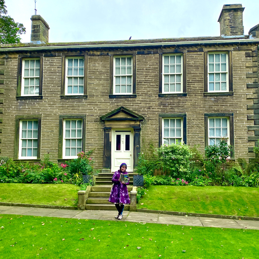 Reading the Brontes in front of the Bronte Parsonage Museum