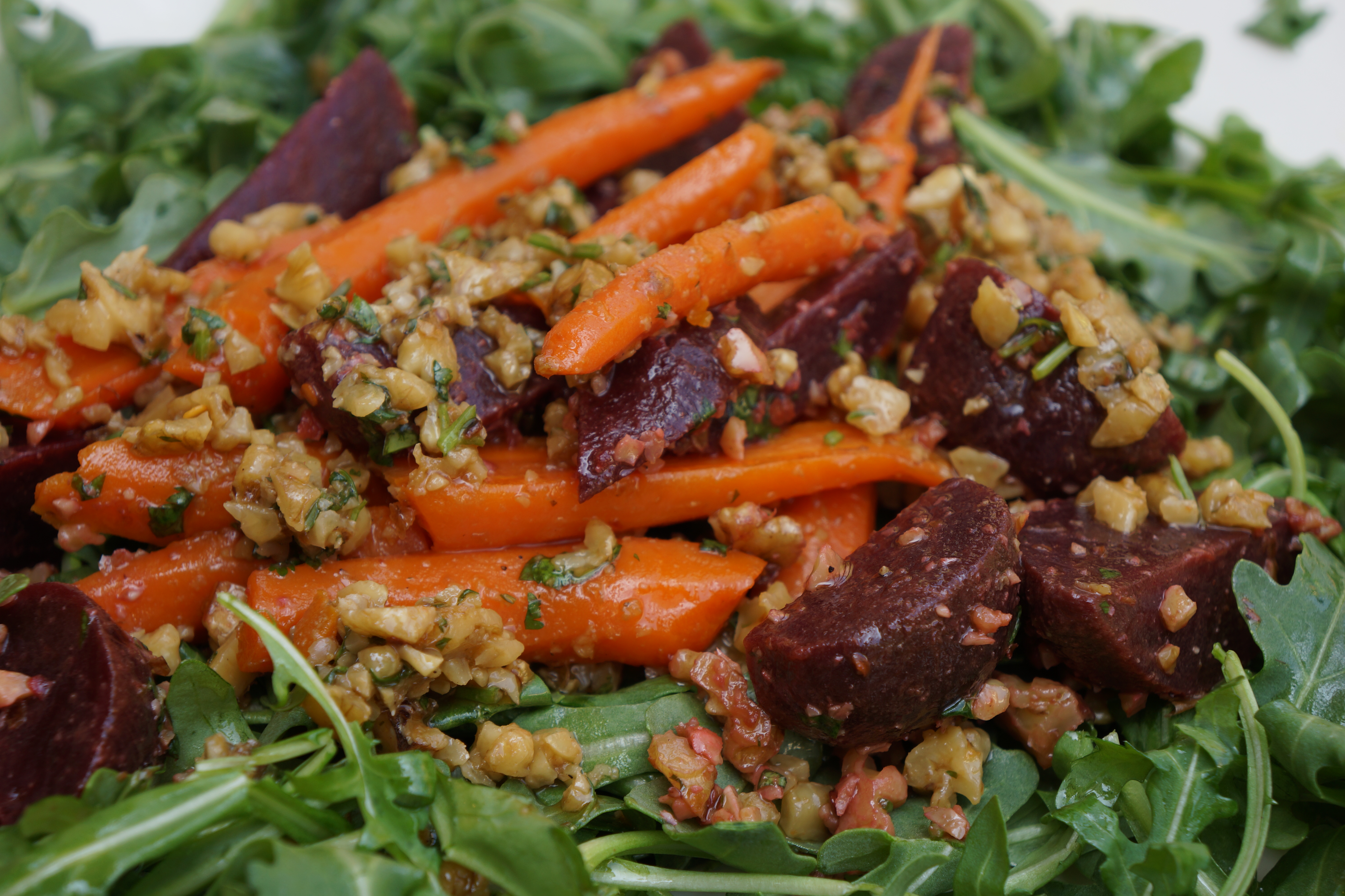 This Spicy Walnut, Beet & Carrot Salad has fresh garlic, pomegranate molasses and cooked root vegetables, all on a bed of baby arugula. YUM!