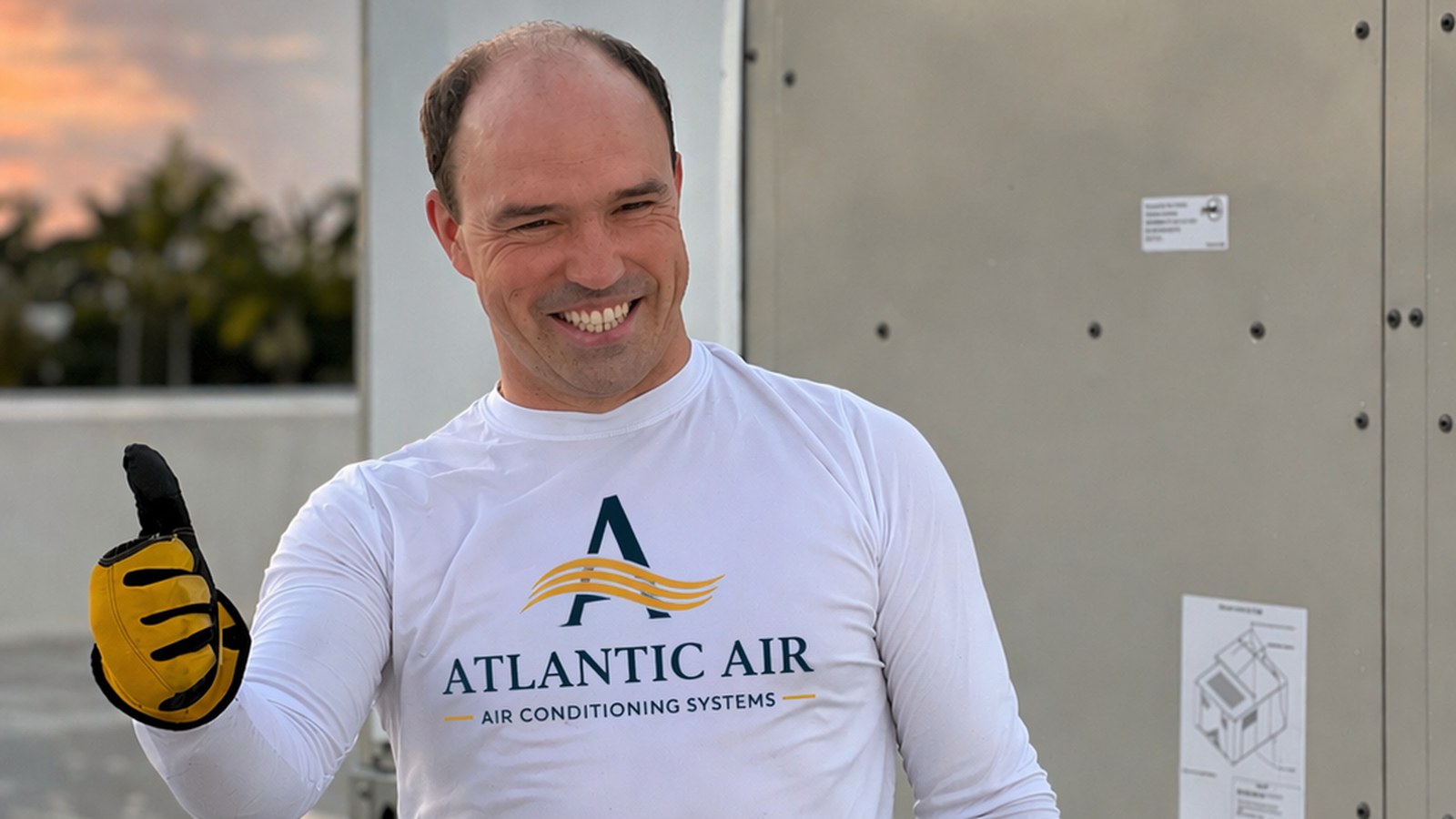 AtlantFlow AC & HEAT technician with Daikin rooftop unit at sunset — 24/7 HVAC South Florida