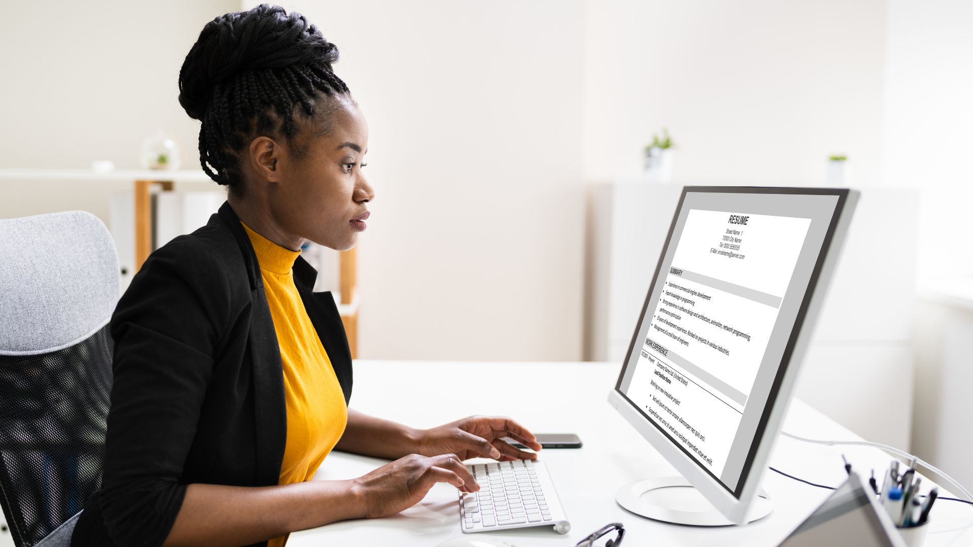 Black woman working on her ATS-friendly resume, focusing on job application success.