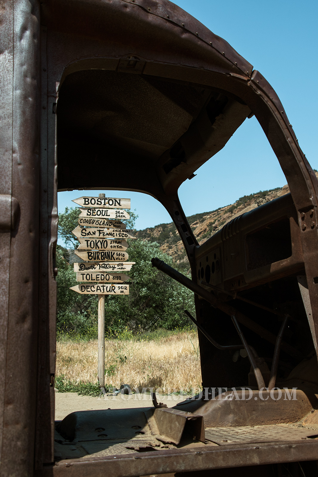 Peeking through the rusted out ambulance used in the show with the sign post in the background.