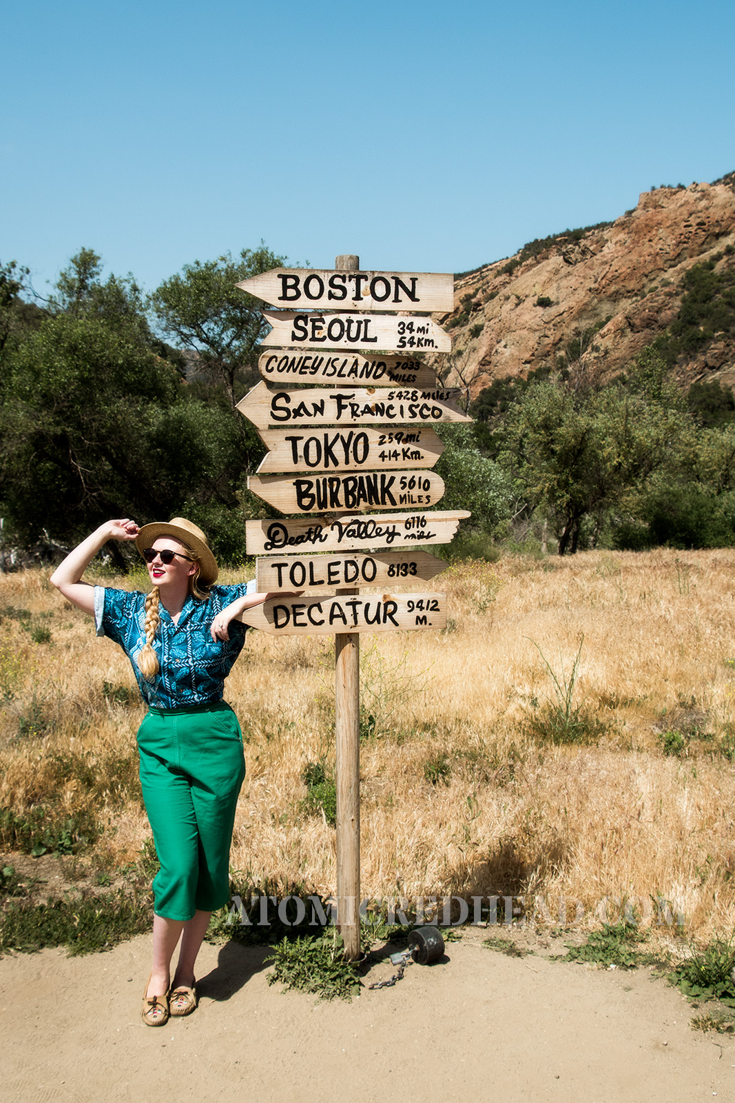 Standing in front of a recreation of the sign post reading where many of the characters were from.